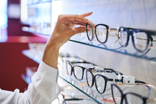 female hand taking eyeglasses from shelf in optica 2024 10 18 10 04 47 utc
