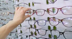 showcase with glasses in the store, hand choosing glasses
